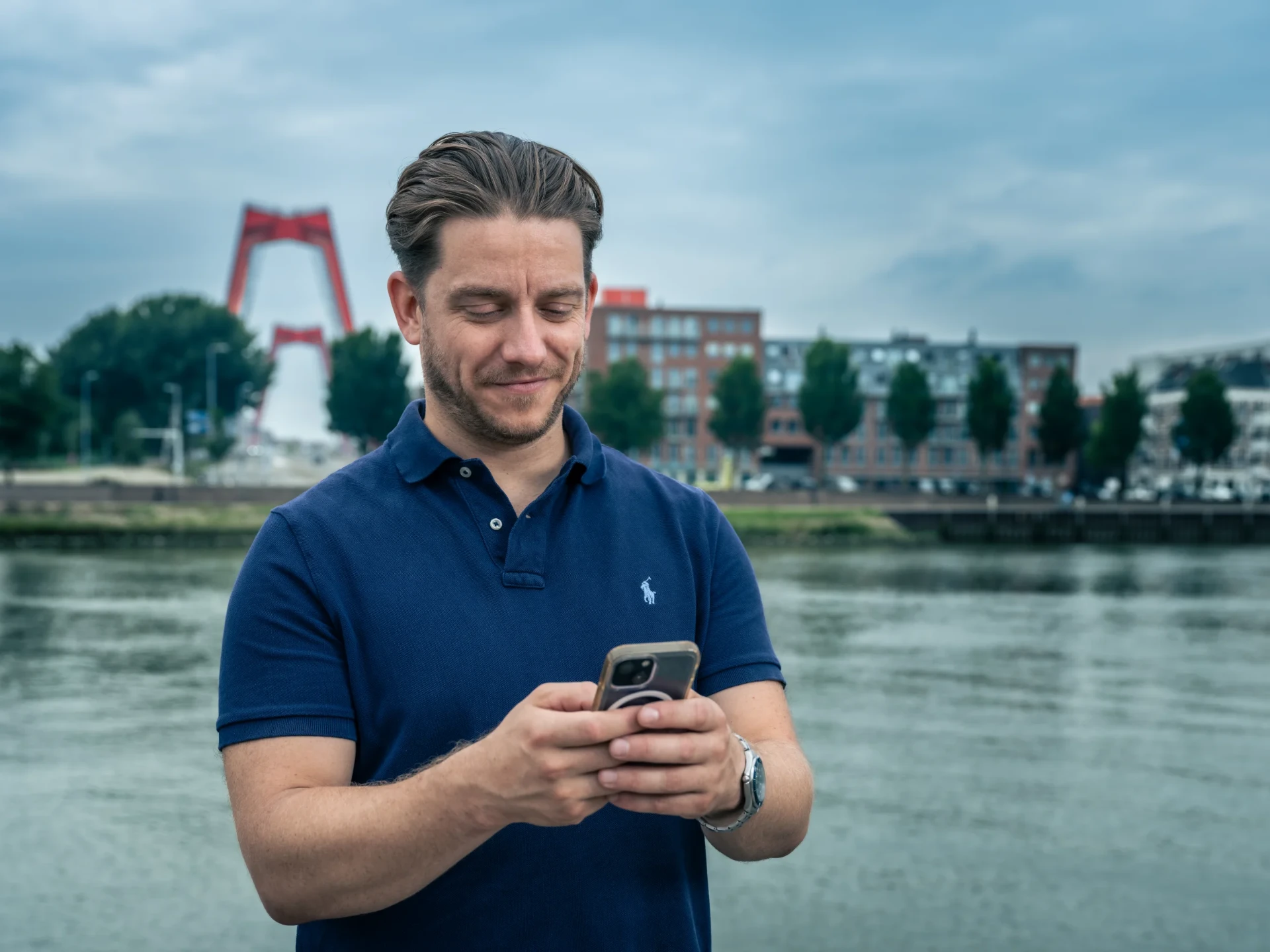 Ondernemer met smartphone bij de Erasmusbrug in Rotterdam
